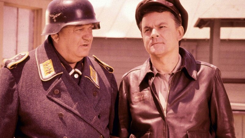 Sgt. Hans Georg Schultz (John Banner, l.), Colonel Robert E. Hogan (Bob Crane) – Bild: TVNOW