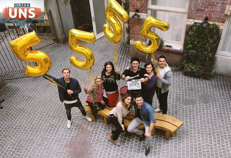 Die UNTER UNS-Schauspieler (stehend v.l.) Aaron Koszuta, Isabell Hertel, Tabea Heynig, Luca Maric, Petra Blossey, Cronis Karakassidis, (vorne) Claudelle Deckert und Milos Vukovic feiern die 5.555 Folge UNTER UNS. – Bild: 0999birgit.muenzer@rtl.de