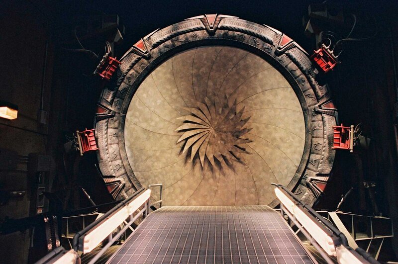 Während einer Mission wird das Team von den Goa’Uld attackiert. O’Neill, Carter und Daniel schaffen es gerade noch rechtzeitig, sich durch das Sternentor zu retten. Nur Teal’c geht irgendwo im Raum verloren … – Bild: SYFY