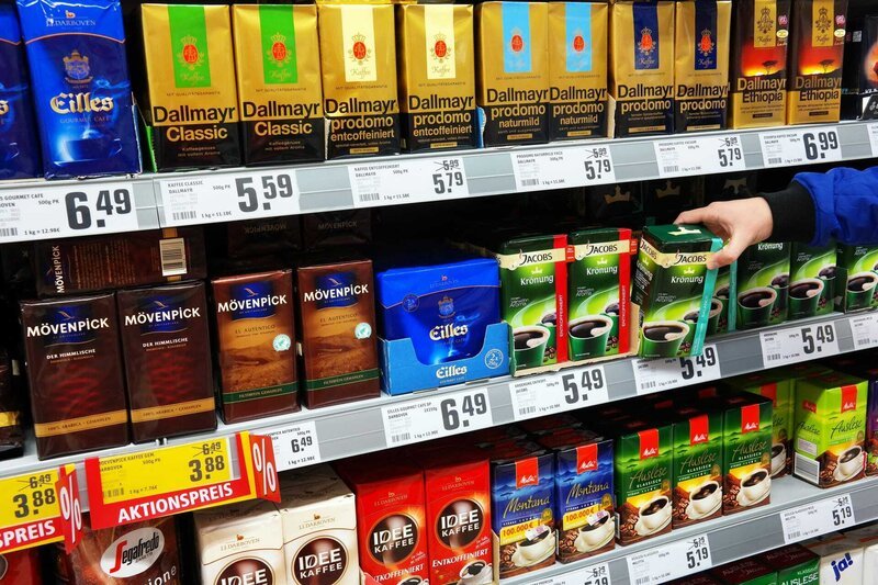 Selecting coffee on a shelf with a variety of coffee products of different brands in a Rewe supermarket. Coffee is one of the most popular drinks in the world. – Bild: Shutterstock /​ Shutterstock /​ Copyright (c) 2017 defotoberg/​Shutterstock. No use without permission. /​Editorial Use Only.