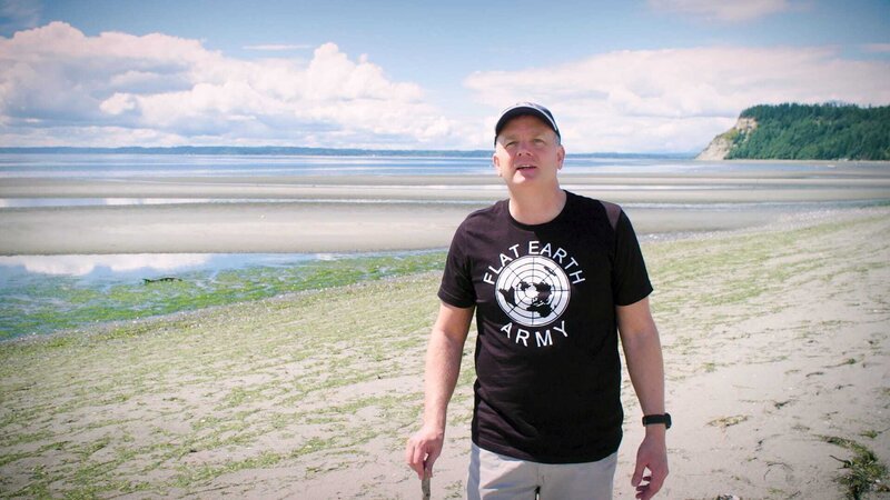 Mark Sargent demonstriert an einem Strand auf Whidbey Island, Washington, warum er glaubt, dass die Erde flach ist. – Bild: ORF/​The Film Sales Company