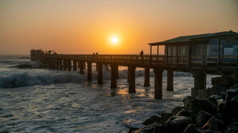 Sonnenuntergang an der alten Landungsbrücke in Swakopmund, Namibia, dem ehemaligen Deutsch-Südwestafrika. – Bild: WDR/​Martin Kießling/​Zeitsprung Pictures
