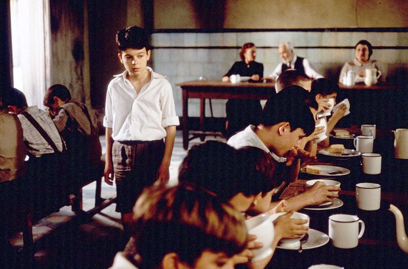 Das Rückgrat des Teufels – Bild: 2001 Sogepaq /​ Carlos (Fernando Tielve, Mi.) sagt den beiden Waisenhausleitern Carmen (Marisa Paredes, hi. li.) und Dr. Casares (Federico Luppi, hi. Mi.) nicht, wer ihn in seiner ersten Nacht dazu angestiftet hat, das Bett zu verlassen.