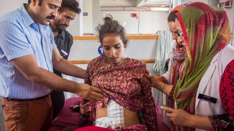 ANANTNAG, KASHMIR – JULY 05: Doctor Malik Azad checks Khalida Akhter, 18, after the surgery at the Mirza Mohd. Afzal Beigh Memorial Hospital or Government District Hospital on July 05, 2015 in Anantnag, Kashmir. Doctors in Kashmir claim to have removed the world’s biggest cyst – weighing a massive 48.5 lbs. The giant cyst, which weighed more than a five-year-old child, was removed from an 18-year-old patient Khalida Akhtar. Doctors removed the growth from the teenagers ovary after Khalida arrived at the hospital complaining of discomfort and a severe abdominal pain. PHOTOGRAPH BY Shams Ul haq Qari /​ Barcroft India – Bild: Discovery Communications /​ Photobank. Original filename: 34 /​ Discovery Communications