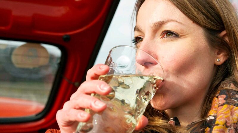 Christina Fischer mit dem für die Pfalz typischen Schorleglas, dem sogenannten „Dubbeglas“. – Bild: HR Christina Fischer mit dem für die Pfalz typischen Schorleglas, dem sogenannten „Dubbeglas“. – Bild: HR
