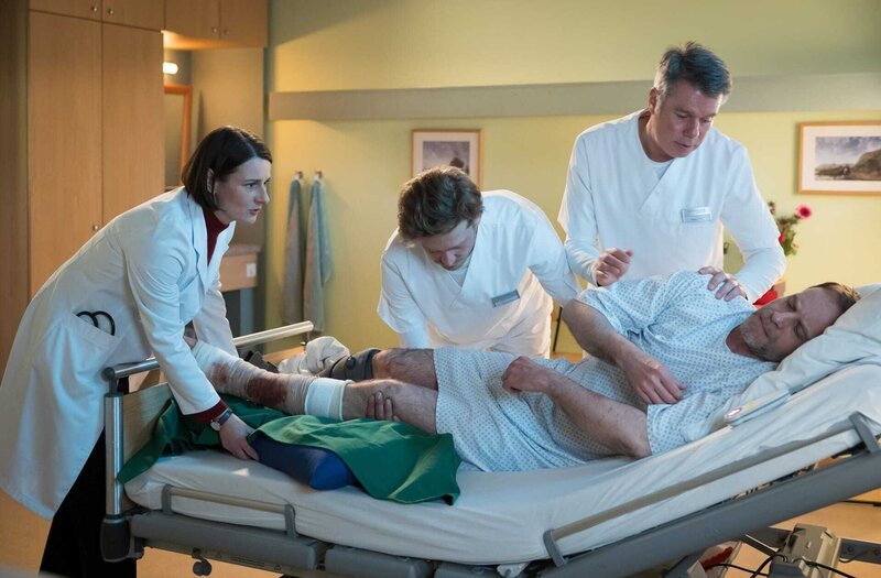 Dr. Kai Hoffmann (Julian Weigend, re.) kann seine eigene Hilflosigkeit nach der Verletzung durch eine Tellermine nicht ertragen. Doch noch viel weniger erträgt er das Mitleid des Klinikpersonals (beide Komparsen in der Mitte) und das seiner Ex-Lebensgefährtin Prof. Dr. Maria Weber (Annett Renneberg, li.). – Bild: MDR/​Saxonia Media/​Rudolf Wernicke