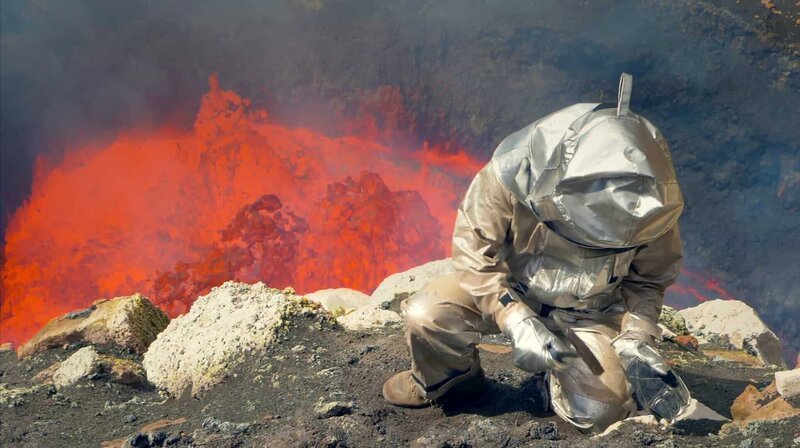 1000 Grad Celsius heiße Lava im Rücken. Am Vulkan Ambrym auf Vanuatu entnimmt der Geologe Jens Kallmeyer Proben am aktiven Lava-See. – Bild: Phoenix/​ZDF und Alex Ranken; True to Nat