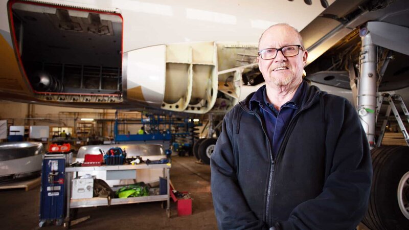 1 contributor in Hangar with plane in background – Bild: Digichemistry /​ © TCB