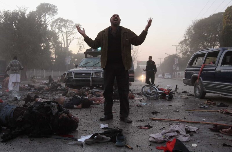 RAWALPINDI, PAKISTAN – DECEMBER 27: (EDITORS NOTE: THIS IMAGE CONTAINS GRAPHIC CONTENT) A survivor stands amidst the carnage of dead and wounded following a bomb blast attack on former Prime Minister Benazir Bhutto December 27, 2007 in Rawalpindi, Pakistan. The opposition leader has died from wounds to the neck and head after speaking at an election rally in the northern city where an estimated 15 people were left dead by the explosion, party officials have been quoted as saying. (Photo by John Moore/​Getty Images) – Bild: John Moore /​ Getty Images /​ Getty Images Europe /​ Getty Images
