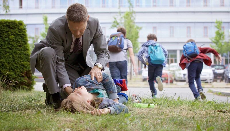 Dr. Rolf Kaminski (Udo Schenk) geht dazwischen, als Rico Graf (Oliver Szerkus, liegend) von anderen Kindern verprügelt wird. Er bringt den verletzten 10-Jährigen sofort in die Sachsenklinik. – Bild: MDR/​Saxonia/​Wernicke