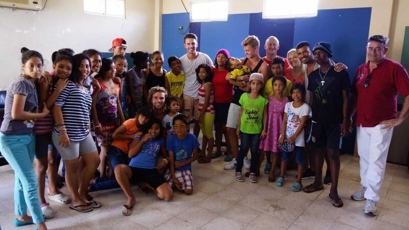 Die Bandmitglieder von Feuerherz und Crew der MS Artania überreichen Spenden im Kinderheim in Guayaquil, Ecuador. – Bild: Bewegte Zeiten Filmproduktion GmbH/​BR/​Deborah Stöckle