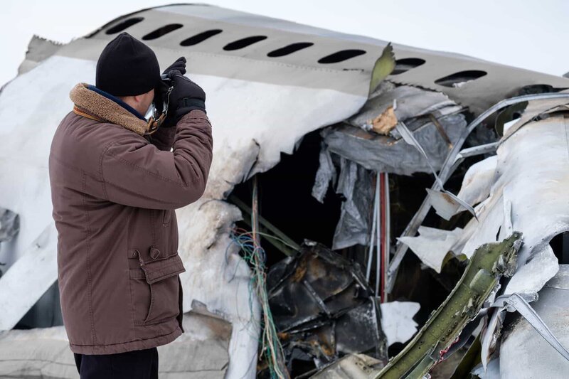 A member of the team (played by a background actor) photographs the wreckage of Continental Airlines flight 1713. – Bild: Cineflix /​ Darren Goldstein