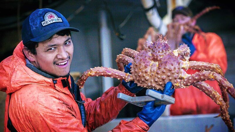 Ein Mitglied der „Wizard“-Crew hält eine große Krabbe. – Bild: Warner Bros. Discovery
