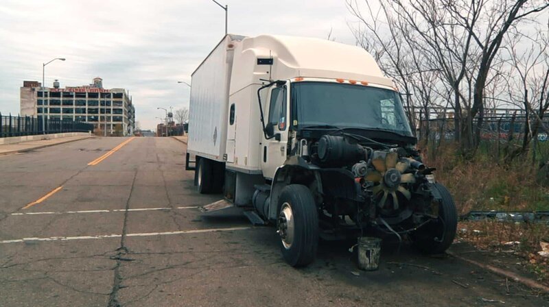 Ein kaputter Truck am Straßenrand in Detroit, im Hintergrund leerstehende Gebäude. – Bild: WDR/​filmproduktion loekenfranke