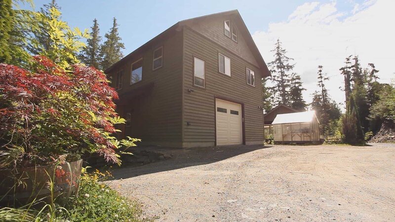 Exterior, side of Clover Pass Waterfront house, driveway, garage, greenhouse, complete with green paint, near Ketchikan, Alaska, as seen on Great American Country’s Living Alaska – Bild: 2016,Great American Country/​Scripps Networks, LLC. All Rights Reserved