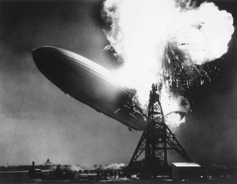 Das deutsche Passagierluftschiff Hindenburg Sekunden nach dem Ausbruch des Feuers am 6. Mai 1937. In einer Höhe von 200 Fuß über dem Boden brechen die Flammen auf der Oberseite und im hinteren Teil des Schiffes aus. Es sank, während es brannte – Bild: shutterstock
