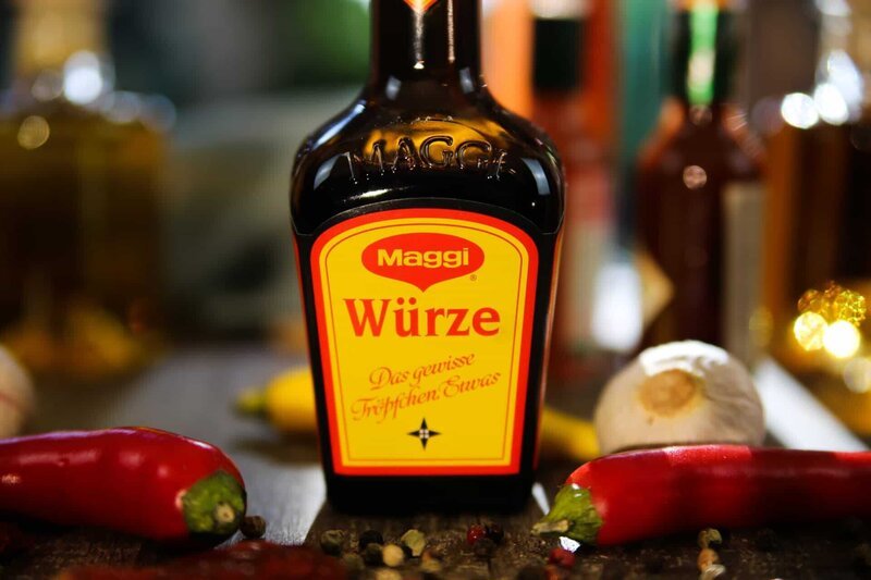 Viersen, Germany – July 9. 2020: Closeup of isolated Maggi seasoning sauce bottle on wood table with garlic and chillis – Bild: Shutterstock /​ Shutterstock /​ Copyright (c) 2020 Ralf Liebhold/​Shutterstock. No use without permission./​editorial use only