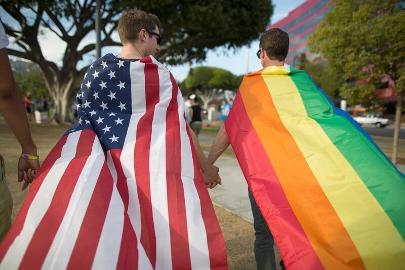WEST HOLLYWOOD, CA – JUNE 26: Robert Oliver and Mark Heller (R) hold hands, draped in flags, as they celebrate the Supreme Court ruling on same-sex marriage on June 26, 2015 in West Hollywood, California. The Supreme Court ruled today that same-sex couples have a constitutional right to marry nationwide without regard to their state’s laws. – Bild: David McNew /​ 2015 David McNew