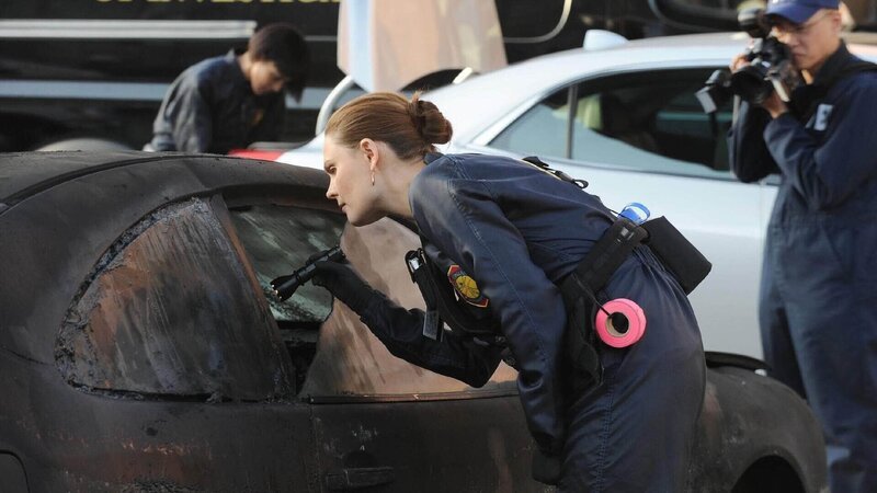 Brennan (Emily Deschanel) macht sich vorsichtig ein Bild von der vekohlten Leiche in dem ausgebrannten Auto. – Bild: TVNOW/​Fox