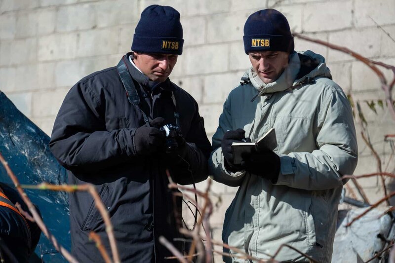 Two NTSB investigators compare findings at the site where United Express 6291 crashed into an industrial warehouse. – Bild: Cineflix 2018