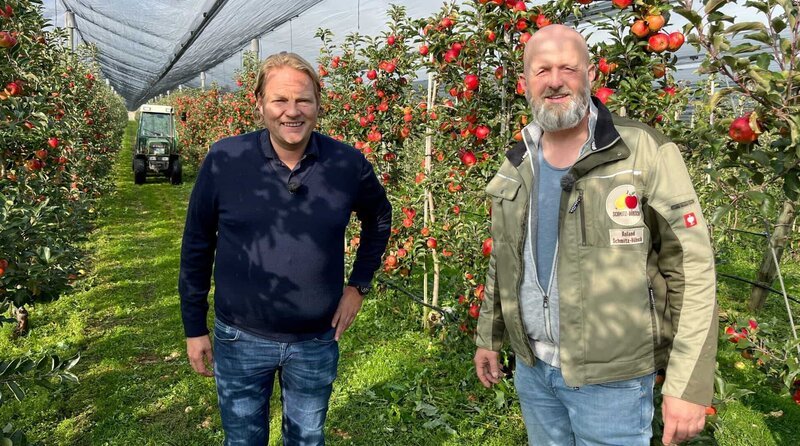 Björn Freitag (l.) lässt sich von Obstanbauer Roland Schmitz-Hübsch (r.) die Apfelernte erklären. – Bild: WDR/​solisTV/​Joshua Stolz
