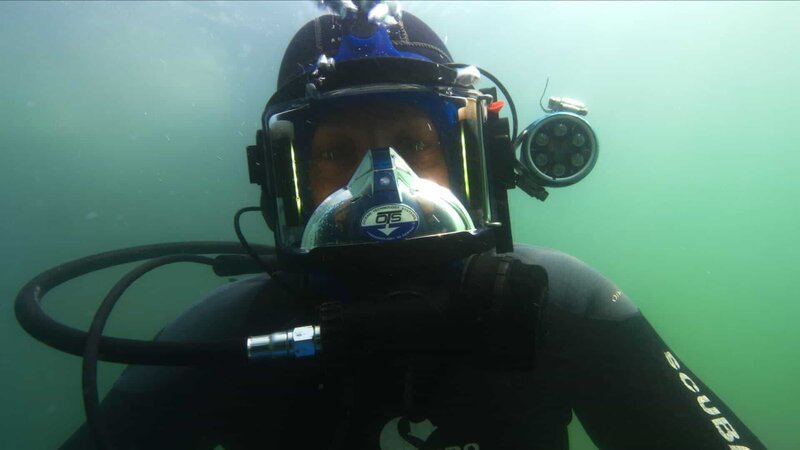 Kris Kelly looks at the camera underwater as he goes down for a dive. – Bild: Discovery Channel /​ Photobank 36840_ep907_016 /​ Discovery Communications, LLC