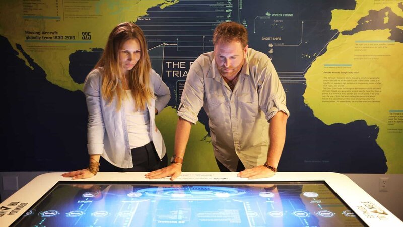 Josh meets with Exhibit Project Manager Svetlana Leksina at the Bermuda Underwater Exploration Institute to learn more about the Bermuda Triangle phenomenon. – Bild: Discovery Channel /​ Discovery Communications, LLC