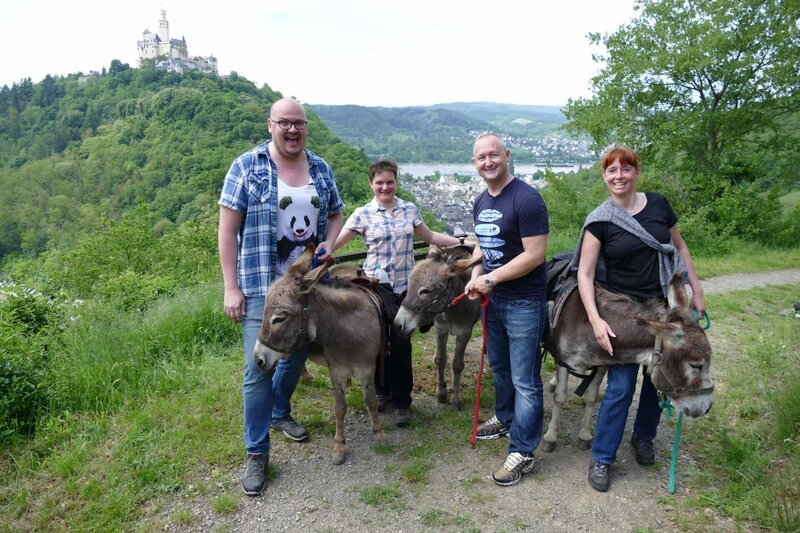 Die Passagiere André und Nicole sowie der Praktikant der Reiseleitung Bernd Walisch machen eine Wanderung mit Eseln in Braubach. – Bild: BR/​Susanne Schmoelz