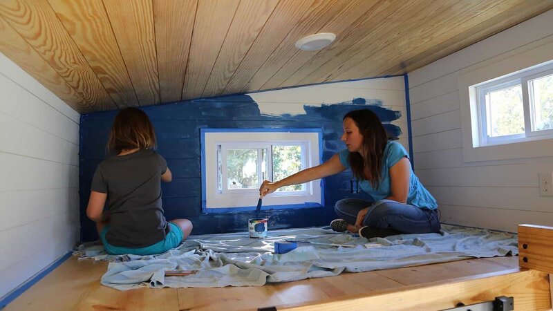 Tiny house owner and builder Sheradan Pate works with her daughter Sage to paint an accent wall in her loft using blue chalkboard paint, as seen on Tiny House, Big Living. – Bild: 2017, Scripps Networks, LLC. All Rights Reserved.