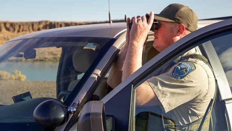 Officer Bushing checking out the surroundings with binoculars. – Bild: Discovery Communications