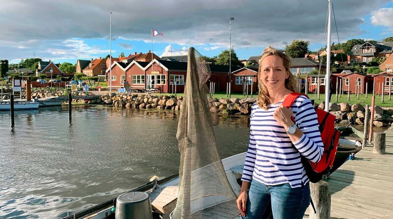 Die typisch roten Holzhäuser findet Tamina Kallert auch im idyllischen Hafenstädtchen Nysted. – Bild: BR/​WDR/​Carolin Wagner/​Carolin Wagner