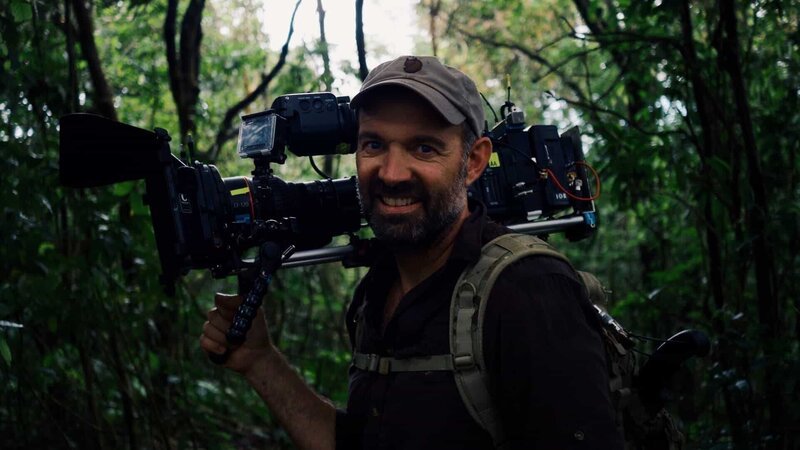 Paul Mungeam has a camera in the jungle smiling. – Bild: Animal Planet /​ Discovery Communications