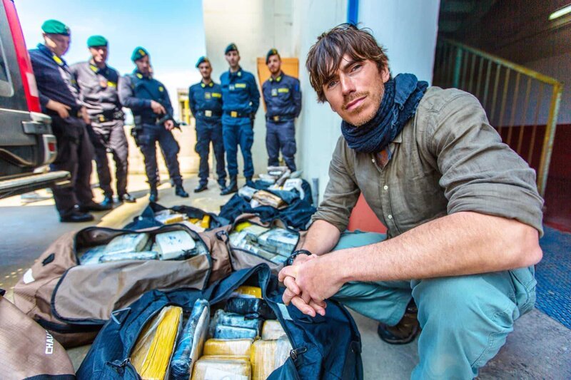 Picture Shows_Simon Reeve with Italy’Äôs anti-smuggling police and over a tonne of cocaine confiscated from the Mafia, worth an estimated two hundred million pounds – From ‚The Mediterranean with Simon Reeve‘, first broadcast in 2018 – Bild: Craig Hastings/​BBC/​The Garden /​ BBC/​The Garden Productions/​Craig /​ BBC/​The Garden Productions /​ © BBC/​The Garden Productions 2021