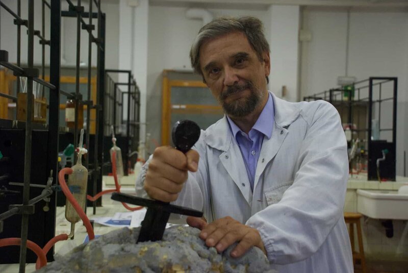 Pavia, Italien – Luigi Garlaschelli (Mitwirkender) an der Universität von Pavia – Luigi zeigt Raluca einige der Ergebnisse der Tests, die er an dem Schwert/​Stein durchgeführt hat. – Bild: NGC /​ NGC /​ WAGtv