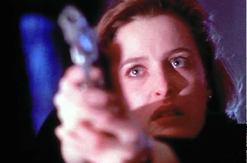 Weil sie glaubt, ihr Kollege sei zur anderen Seite übergelaufen, bedroht ihn Scully (Gillian Anderson) … – Bild: SYFY