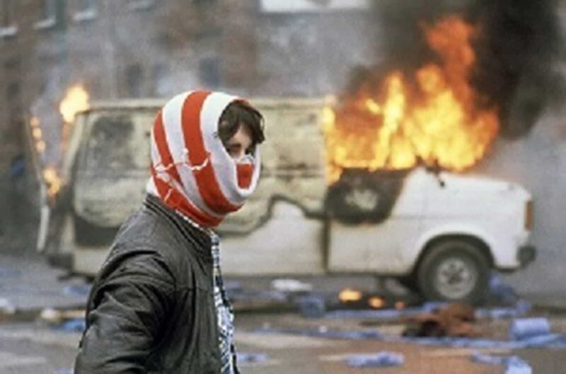 Jugendlicher vor einem brennenden Lieferwagen, Belfast 1981 – Bild: Associated Press/​Robert Dear /​ Jugendlicher vor einem brennenden Lieferwagen, Belfast 1981