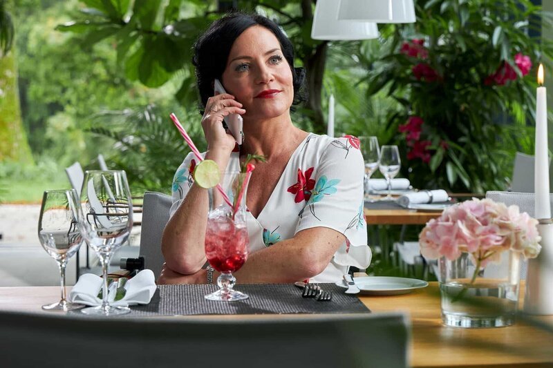 Frau Stockl (Marisa Burger) versucht, ihren wohlverdienten Urlaub in Südfrankreich zu genießen, auch wenn ihre Vertretung sie wegen der ein oder anderen Frage anruft. – Bild: ZDF/​Bojan Ritan