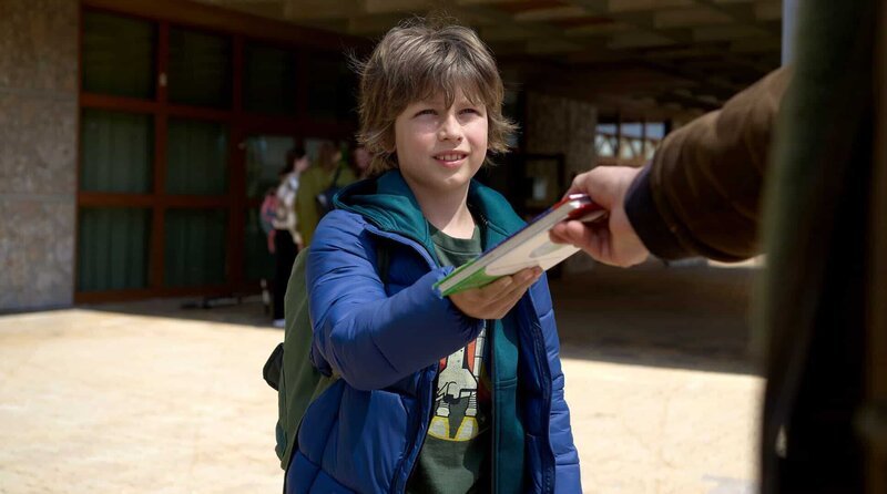 Tim (Lilian Rosskopf) wird auf dem Schulhof von einem Unbekannten angesprochen. – Bild: Barry Films/​Mona Film/​Stephan Burchardt