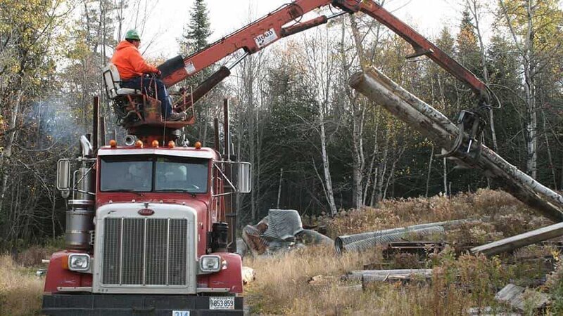Guy on crane lifting wood. – Bild: Discovery Communications