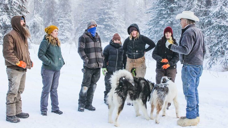 Marty (r.) unterhält sich mit (v.l.n.r.) Matt, Katie, Maciah, Gauge, Misty und Mollee im Schnee, während zwei Hunde in der Nähe sind. – Bild: Scott Sandman /​ Discovery Channel /​ Photobank: 37473_ep111_016.jpg /​ Discovery Communications, LLC
