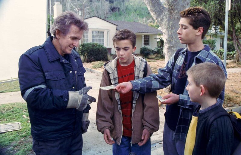 Malcolm (Frankie Muniz, 2.v.l.), Reese (Justin Berfield, 2.v.r.) und Dewey (Erik Per Sullivan, r.) kaufen dem Müllmann (Clement Blake, l.) ein altes Mini-Bike ab. – Bild: ViacomCBS