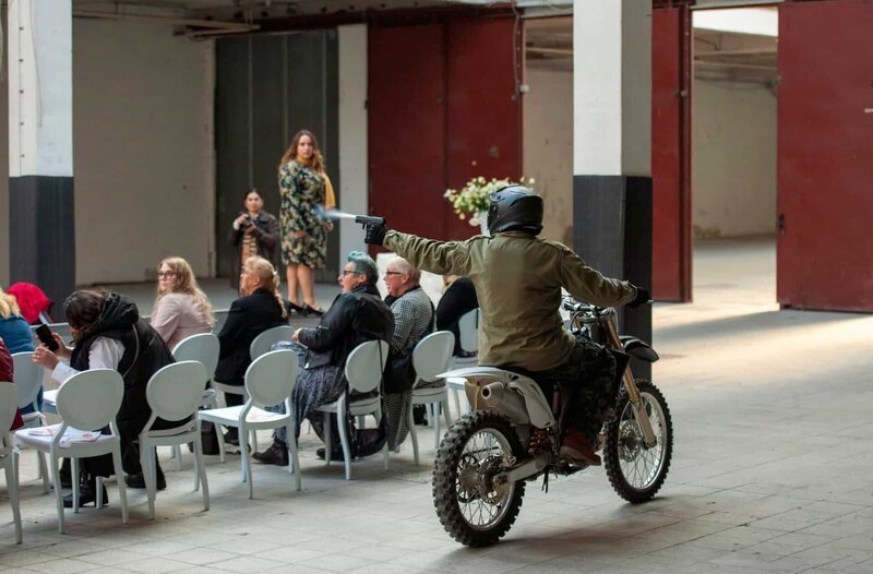 Der Attentäter schießt vom Motorrad aus auf eines der Models auf dem Laufsteg. – Bild: ARD/​Thorsten Jander