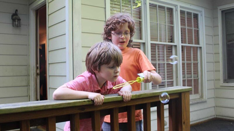 Hemphill family sons blow bubbles on the back porch in family package segment in episode 209, as seen on HGTV’s House Hunters Family – Bild: 2018, Scripps Networks, LLC. All Rights Reserved.