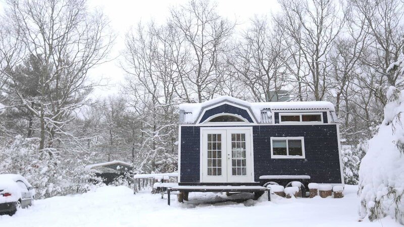 Snow flurries gently fall to the ground and cover Jesse and Nora’s completed tiny house and traveling theater, on a blustery winter day, in Richmond, Rhode Island, as seen on Tiny House, Big Living – Bild: 2018, Scripps Networks, LLC. All Rights Reserved.