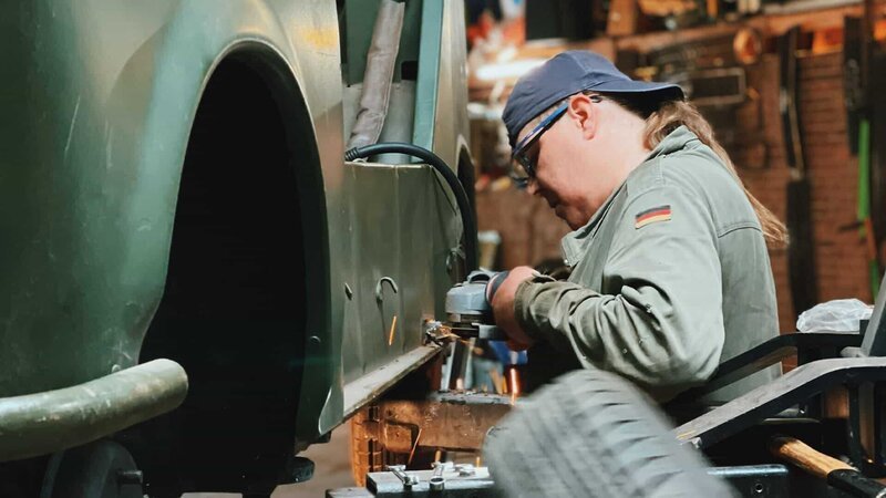 Mechaniker bei der Arbeit an dem 40 Jahre alten Kübel-Trabi. – Bild: Warner Bros. Discovery