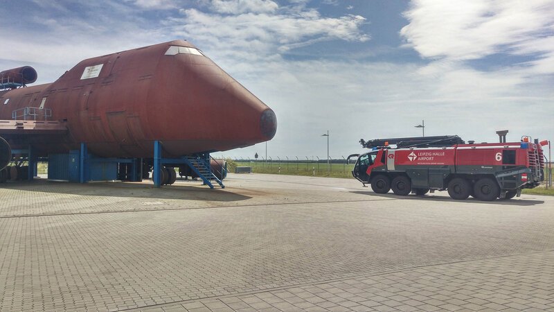 Die Feuerwehr des Flughafens Halle-Leipzig trainiert auf dem Übungsplatz stets realistische Einsätze mittels besonderer Technik. Das Feuerwehrfahrzeug „Panther“ (Foto r.) verfügt unter anderem über einen Wasserwerfer, der eine Reichweite von bis zu 90 Metern misst, sodass der Brand eines Flugzeugs auch im Ernstfall schnell gelöscht wäre. – Bild: BILD