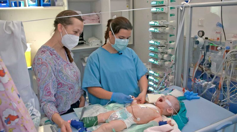 Gustav kam mit einem angeborenen Herzfehler auf die Welt. Pflegerin Ricarda (rechts) und Mama Dina Weide versorgen ihn auf der Kinderintensivstation. – Bild: ZDF und NDR/​Stefan Radüg/​nahaufnahme.tv.