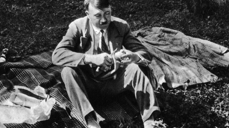 Adolf Hitler (1889–1945), ca. 1933 während eines Picknicks zwischen zwei Terminen. – Bild: TVNOW /​ Hulton Archive/​Heinrich Hoffmann/​Getty Images