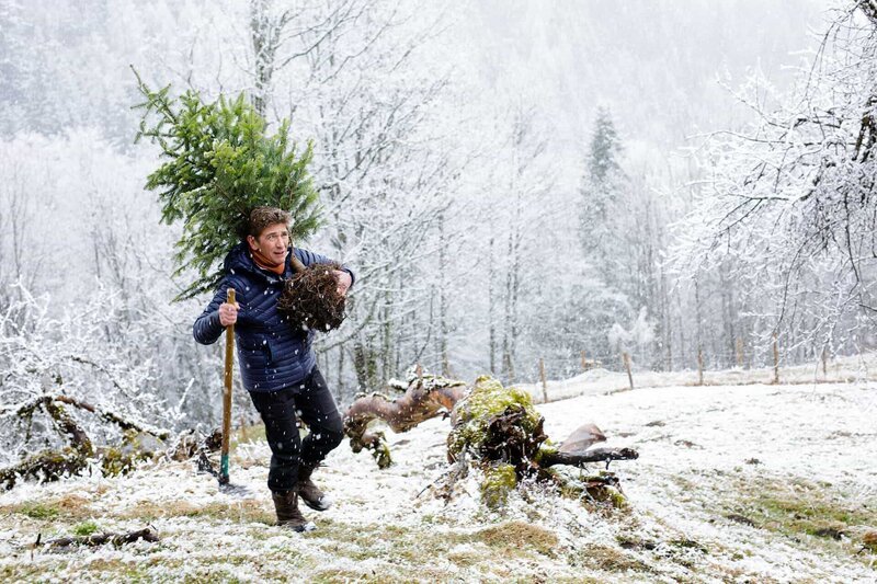 Ohne Weihnachtsbaum läuft nichts. Der grantige Bauer hat Fritz Fuchs (Guido Hammesfahr) sogar eine Hacke geliehen. um einen Baum auf der Alm auszubuddeln. – Bild: ZDF und Andrea Hansen Fotografie.