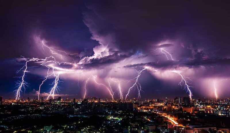Lightning storm over city in purple light – Bild: Deposit